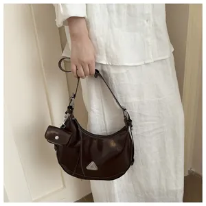 Close-up detail of dark brown hobo shoulder bag with a small pouch attachment