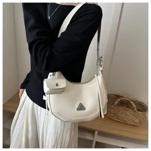 Close-up detail of a white crescent shoulder bag worn with a matching small pouch