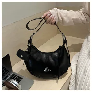 Detailed shot of a black faux leather crescent hobo bag with silver metallic hardware accent