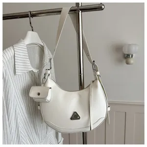Modern white crescent hobo bag with detachable coin pouch on a minimalist rack