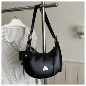 Black crescent moon hobo shoulder bag with a mini pouch detail on a metal rack