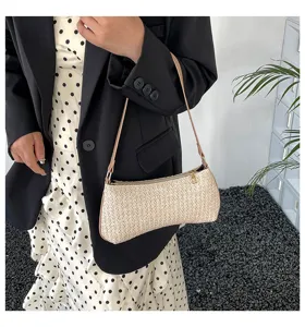 Πλεκτή ψάθινη τσάντα ώμου σε μοντέλο που φοράει κομψό πουά φόρεμα