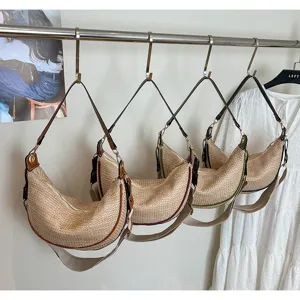 Sacs en paille tressée en plusieurs couleurs suspendus à un portant pour le style plage