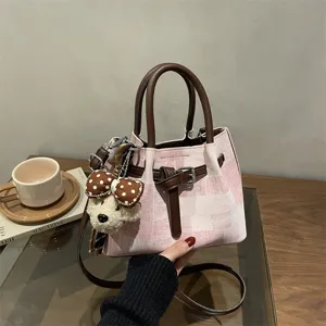 Retro pink and brown patchwork bucket bag featuring a cute teddy bear charm accessory