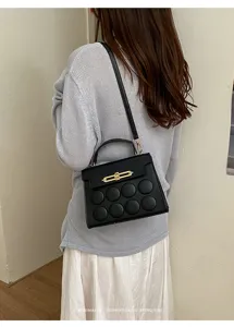 Close-up of model wearing black minimalist retro handbag with unique circular pattern