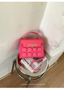 Minimalist pink niche design small square handbag with unique circular relief detailing.