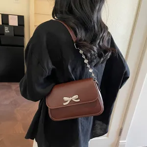 Elegante braune Unterarmtasche für Damen mit süßer Strass-Schleife und Kettenriemen