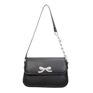 Elegante schwarze minimalistische Achseltasche mit einer funkelnden Kristallschleife