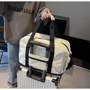 Large capacity travel duffel bag detail showing luggage sleeve and sturdy black handles.