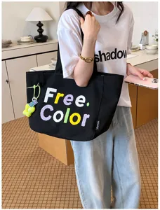 Black canvas shoulder tote bag with colorful embroidery letters for daily casual fashion use.