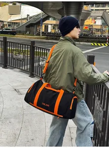 Detail shot of large capacity travel duffel bag with black and orange design for fitness.