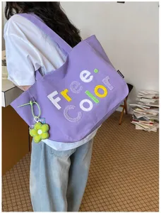Purple canvas shoulder tote bag detail view featuring embroidered letters and cute flower charm