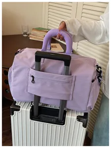 Purple travel duffel bag with luggage trolley sleeve showing convenient storage detail.