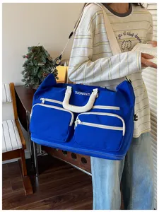 Large capacity travel duffel bag with multiple pockets, blue canvas fabric, shoulder strap.