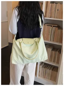 Large capacity nylon travel shoulder bag with stylish embroidery and top handle design.