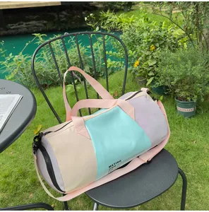 Pastel color block duffel travel bag outdoor lifestyle detail showing large capacity design.