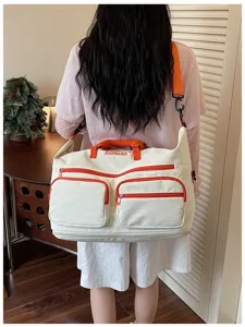 Large capacity travel duffel bag for short trips, lightweight canvas luggage with orange details.