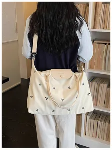 Beige canvas travel tote bag with cute black bow embroidery, large capacity shoulder bag.