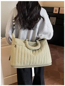 Vue détaillée du grand sac de voyage matelassé avec bandoulière, montrant le design.