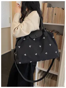 Large capacity travel duffel bag with stylish bow print and sturdy shoulder strap.