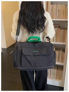 Large capacity travel duffel bag with green handle for weekend trips and sports use.