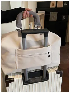 Beige travel duffel bag with luggage sleeve and zipper pocket, perfect for short trips and flights.