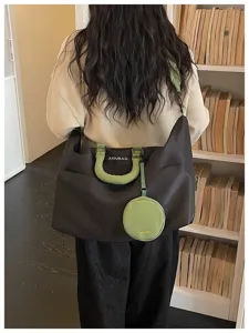 Detail view of large capacity travel duffel bag in black and green with cute round pouch.