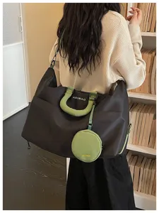 Large capacity travel duffel bag with green handles and round pouch for short trips.