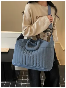 Vue de détail rapprochée du sac de voyage matelassé bleu avec compartiment inférieur.