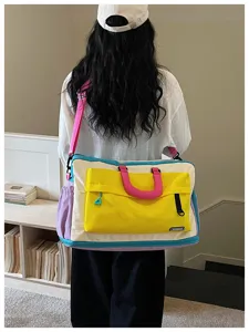 Vista dettagliata della borsa da viaggio colorblock con scena di trasporto e tasche utili.