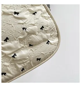 Close-up view of textured bubble gauze fabric with small black bow patterns