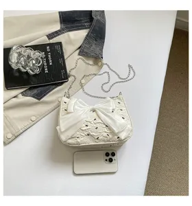Fashionable white bubble gauze shoulder bag featuring a large bow and chain strap detail