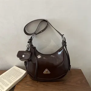 Dark brown glossy crescent hobo bag with a mini pouch in a vintage motorcycle style