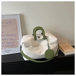 Dettaglio della borsa da viaggio bianca minimalista, con manici verdi e borsellino abbinato.