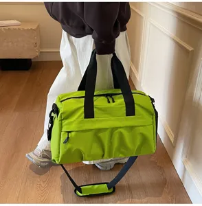 Detailed view of large capacity green travel duffel bag with black straps for gym and sports.