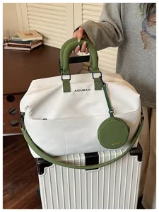 Grande borsa da viaggio con manici verdi e piccola custodia rotonda abbinata per l'uso quotidiano.