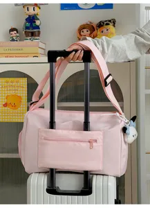 Pink large capacity travel duffel bag with luggage sleeve and cute pendant for women.