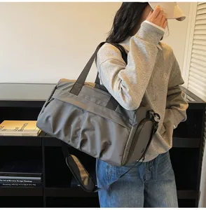Detail shot showcasing the large capacity dark grey travel duffel bag with shoulder strap.