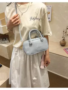 Lifestyle view of light blue bowling pillow bag with embossed brand logo