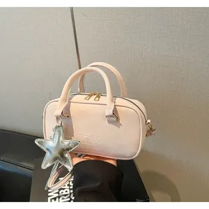 Detailed view of light pink bowling bag featuring a silver star charm and embossed text