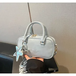 Detailed view of light blue bowling handbag featuring star and balloon dog pendants