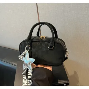 Elegant black suede-like bowling bag detail featuring a stylish silver star charm