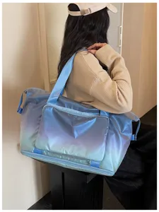 Vue détaillée du sac de voyage élégant en dégradé porté par un mannequin, idéal pour le sport.