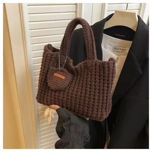 Détail d'un sac à main tricoté à la main marron avec charme coeur de style urbain épuré