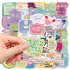 Close-up of positive quote cartoon sticker held in hand, colorful waterproof DIY journal decal.
