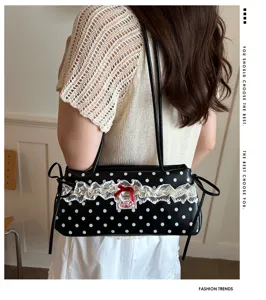 Detail view of vintage polka dot underarm bag with lace trim and red bow accent.
