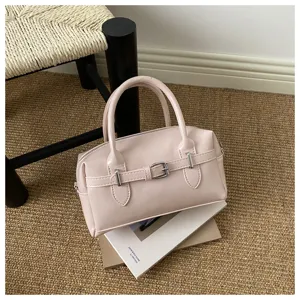 Elegante hellrosa Bowling-Handtasche mit Schnallenriemen auf einem strukturierten Teppich