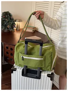 Green travel duffel bag detail, large capacity waterproof luggage bag with trolley sleeve and pockets.