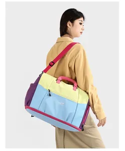 Dettaglio della grande borsa da viaggio con design patchwork multicolore e cinghie resistenti.