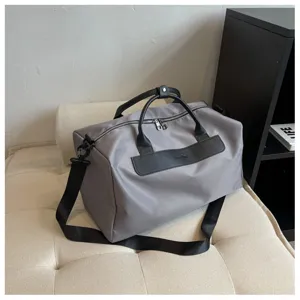 Minimalist gray travel duffel bag with large capacity, durable fabric and shoulder strap.
